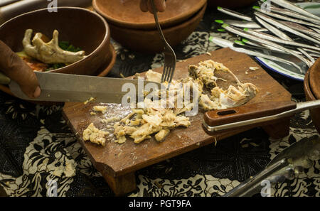 Une tranche de poulet sur planche de bois vendeur sur marché traditionnel avec du poulet de l'alimentation et l'argile de poterie de centre de java Banque D'Images