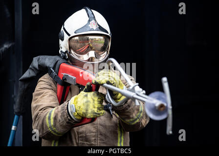 Pompier watch manager Paul Halliday du Service d'incendie et de sauvetage écossais, au Centre National d'entraînement à Glasgow, témoigne d'une lance, à ultra haute pression &marque Ocirc;Coldcut Cobra&Otilde ;, qui permettra aux pompiers d'un extincteur de souffle à travers la paroi d'un immeuble en feu. Banque D'Images