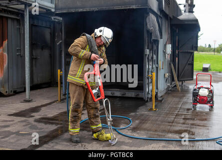 Pompier watch manager Paul Halliday du Service d'incendie et de sauvetage écossais, au Centre National d'entraînement à Glasgow, témoigne d'une lance, à ultra haute pression &marque Ocirc;Coldcut Cobra&Otilde ;, qui permettra aux pompiers d'un extincteur de souffle à travers la paroi d'un immeuble en feu. Banque D'Images