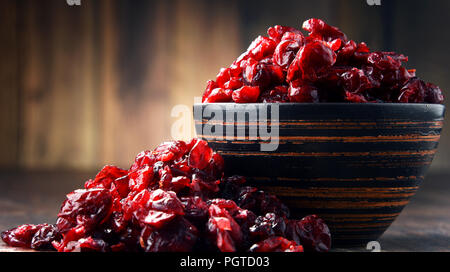 La composition avec bol de canneberges séchées sur table en bois. Banque D'Images