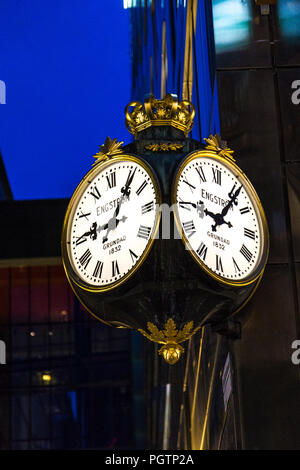 Un écran lumineux orné d'or old-fashion Rob Engstrom réveil avec chiffres romains de nuit sur la rue Drottninggatan, Stockholm, Suède Banque D'Images