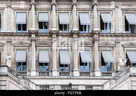 Recouvrir les fenêtres auvents rayés sur un vieux bâtiment avec des détails à Paris France. Banque D'Images