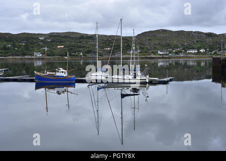 Yachts reflète dans la mer calme à la marina du port, Lochinver Lochinver, Ecosse Banque D'Images