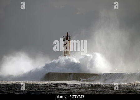 Grosse Vague contre phare dans le nord du Portugal dans un ciel couvert soir orageux - embouchure de la rivière Ave à Vila do Conde Banque D'Images