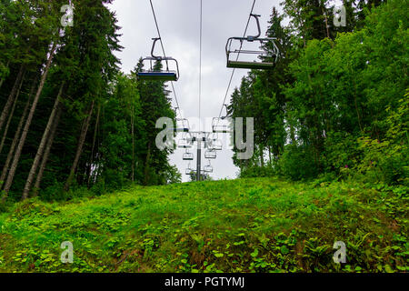 Télésiège de ski dans les montagnes de l'été pluvieux à travers forêt montagne fabuleuse étonnante en Bukovel, Carpates ukrainiennes Banque D'Images