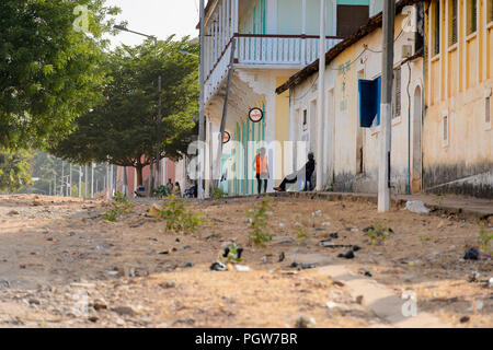 L'ÎLE DE BOLAMA, GUINÉE BISSAU - 6 mai 2017 : local non identifié dans l'homme veste orange promenades le long de la rue dans la ville fantôme de Trebeurden, l'ancienne capita Banque D'Images