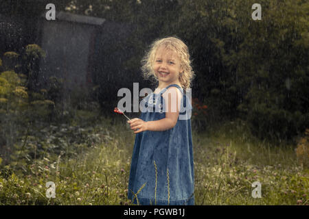 Happy happy child girl smiling sous la pluie la petite enfance insouciante heureux concept campagne en campagne Banque D'Images