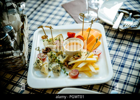 Plateau de fromages assortiment de différents types de fromages et de miel sur plaque blanche.Fromage et vins de table, parti de parfait apéritif. Différents types de fromages.raw food concept. Banque D'Images