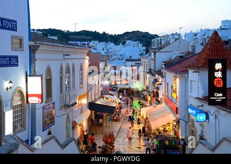 Portrait de la R 5 de Outubro shopping street dans la soirée avec les touristes appréciant les paramètre, Albufeira, Portugal, Europe. Banque D'Images