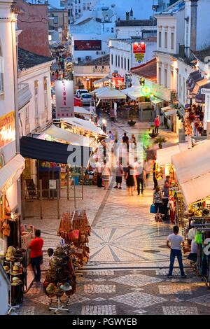 Portrait de la R 5 de Outubro shopping street dans la soirée avec les touristes appréciant les paramètre, Albufeira, Portugal, Europe. Banque D'Images