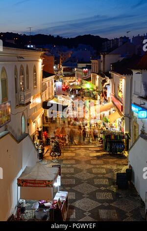 Portrait de la R 5 de Outubro shopping street dans la soirée avec les touristes appréciant les paramètre, Albufeira, Portugal, Europe. Banque D'Images