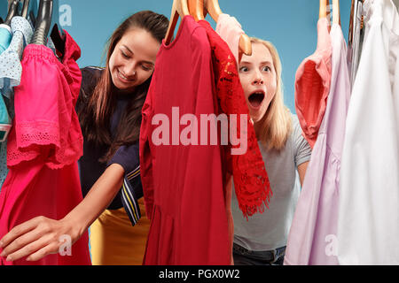 Image de jolies femmes à la recherche d'une robe tout en le sélectionnant. Concept de shopping et mode de vie Banque D'Images