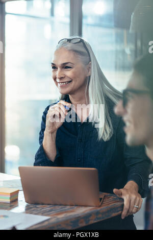 Happy business woman en réunion avec des collègues. Female entrepreneur au cours de réunion avec l'équipe. Banque D'Images