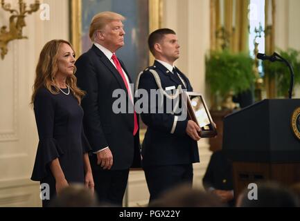 Le président Donald J. Trump et Valerie Nessel, le conjoint de l'US Air Force Tech, 22 août 2018. Le Sgt. John Chapman Comité permanent comme la citation est lue avant de recevoir la médaille d'honneur, Maison Blanche, Washington, D.C. L'image de courtoisie Wayne Clark / secrétaire de l'Affaires publiques de la Force aérienne. () Banque D'Images