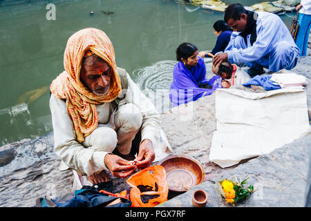 Temple de Pashupatinath, Vallée de Katmandou, Népal, Bagmati, l'Asie du Sud : un brahmane prie par la rivière Bagmati comme un père se rase la tête de son fils comme un deuil Banque D'Images