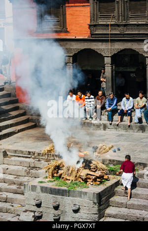 Temple de Pashupatinath, Vallée de Katmandou, Népal, Bagmati, l'Asie du Sud : les gens à assister à une crémation funérailles par la rivière Bagmati au temple de Pashupatinath Banque D'Images