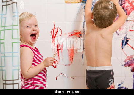 Portrait of two cute adorable petit garçon caucasien et fille jouant de la peinture sur les façades de la salle de bain, s'amusant, le mode de vie de la petite enfance active conce