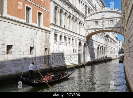 Pont des Soupirs, femme à prendre des photos et de l'homme sur le bateau gondole à au célèbre pont dans une journée ensoleillée à Venise, Italie Banque D'Images