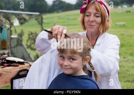 Chepstow, Pays de Galles - 19 Août 14 : Jeune fille bénéficie d'une coupe de cheveux à la pédale powered coiffure le 14 août 2015 au Green Gathering Festival Banque D'Images