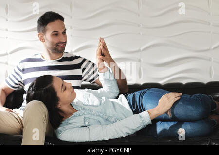 Latino heureux couple Holding Hands And Smiling On Sofa Banque D'Images