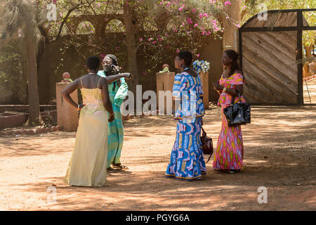 Route de LAMPOUL, SÉNÉGAL - Apr 23, 2017 : quatre femmes sénégalaises non identifiés en vêtements traditionnels parlent de quelque chose. Encore beaucoup de personnes au Sénégal Banque D'Images