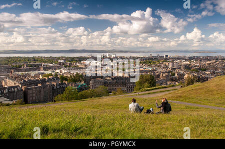 Édimbourg, Écosse, Royaume-Uni - 30 mai 2011 : Les gens s'asseoir dans un parc sur la Colline Calton, bénéficiant d'une journée ensoleillée à Édimbourg, avec le faubourg de Leith et Firth of F Banque D'Images