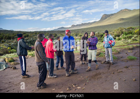 Les porteurs, cuisiniers et guides chanter en Shira Camp 1, Shira Plateau, le Kilimandjaro, la région de Kilimandjaro, Tanzanie. Banque D'Images