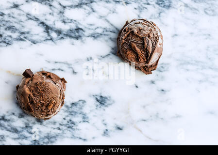 Boules de glace au chocolat sur fond de marbre, vue du dessus Banque D'Images