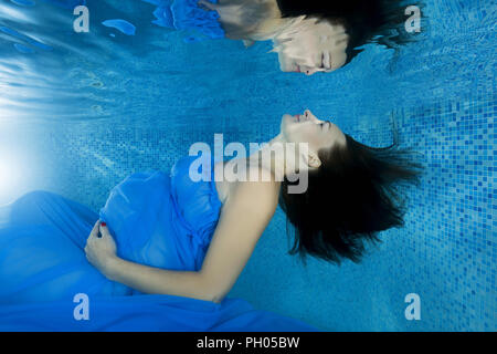 Odessa, Ukraine. Août 27, 2018. Une femme enceinte dans une robe bleue regarde sa réflexion par la vie sous-marine dans la piscine Crédit : Andrey Nekrasov/ZUMA/Alamy Fil Live News Banque D'Images