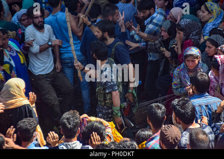 Kulgam, Inde. 29 août 2018. Vu les militants de faire peur au monde avec des bâtons tout en essayant de faire leur chemin à travers la foule.Des milliers de personnes ont participé à la prière funéraire de tué Hizb haut commandant Militant Altaf Ahmed Dar hawoora Alias Altaf Kachroo du Village de South District Kulgam du Cachemire. Altaf était tué avec son associé Umer wani dans un bref échange de coups de feu avec les forces indiennes au Cachemire au sud du District de Ananthnag quelques 60 Kms de la ville de Srinagar, Jammu-et-Cachemire. Credit : Idrees Abbas/SOPA Images/ZUMA/Alamy Fil Live News Banque D'Images