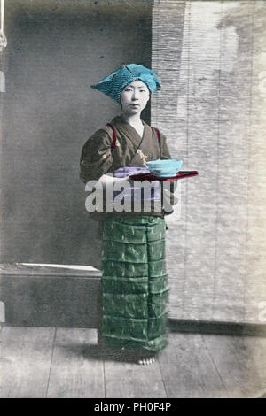 [ 1890 Japon - Japonais Servante ] - une servante en kimono, tablier et chapeau traditionnel dans un pays de thé. Elle est titulaire d'un bac avec un bol. 19e siècle vintage albumen photo. Banque D'Images