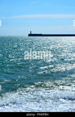 Le phare du port de Newhaven et mur sont au milieu d'une mer soleil bleu au premier plan et le bleu et les nuages blancs dans l'arrière-plan vertic Banque D'Images