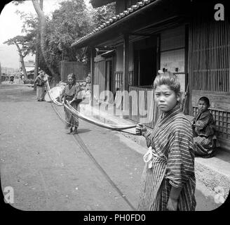[ 1900 Japon - Les femmes qui travaillent avec de la soie ] - deux femmes et une fille habillé en yukata et kimono de soie avec travail en face d'une maison à Kanbara dans la préfecture de Shizuoka. La ville a été a été le quinzième de la cinquante-trois stations du Tokaido autoroute. Le 31 mars 2006, Kanbara a cessé d'exister en tant qu'il est devenu une partie de Shimizu-ku de la ville de Shizuoka. 20e siècle vintage plaque en verre Banque D'Images