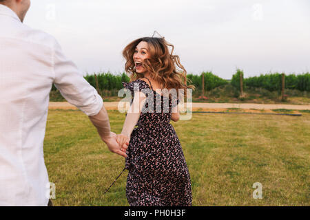 Happy young couple homme et femme marche outdoor ensemble au vignoble sur journée d'été Banque D'Images