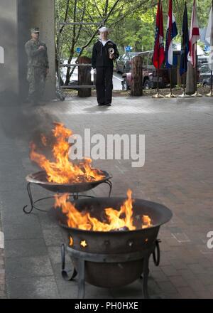 BANGOR, Washington (14 juin 2018) 1ère classe musicien Chris Hodges, de Tuscaloosa, en Alabama, attribué à bande marine nord-ouest, s'établit à l'attention lors d'une cérémonie à la retraite drapeau Naval Base Kitsap - Bangor. Lorsqu'un drapeau des États-Unis est usé, déchiré, délavées ou très sale, le drapeau doit être à la retraite dans la dignité et le respect qui sied à elle. La méthode traditionnelle est de couper le drapeau en morceaux, séparant les bandes 13 à partir de canton et leur incinération séparément de façon respectueuse. Banque D'Images