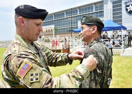 CAMP HUMPHREYS, République de Corée - Le Général de D. Scott McKean, général commandant la 2e Division d'infanterie de Corée et les États-Unis Division combiné place la division combinés patch sur Brig. Le général Kim, Yong Chul, le nouveau commandant général adjoint pour le commandant adjoint de la République de Corée au Patch des généraux sur la cérémonie de la 2e Division d'infanterie le 15 juin sur le terrain de parade. Banque D'Images