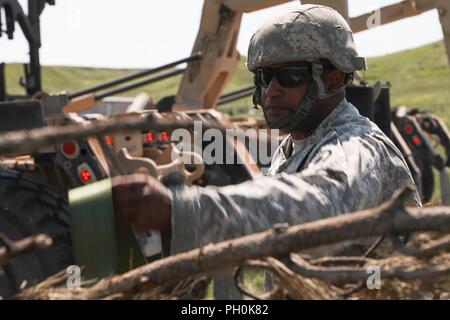 Soldat américain de la 137e compagnie de transport, de la Garde nationale du Kansas, jette une sangle à cliquet pendant la Golden Coyote en chemise rouge, S.D., 15 juin 2018. Le Coyote d'or l'exercice est un trois-phase, axée sur des mises en exercice mené dans les Black Hills du Dakota du Sud et le Wyoming, qui permet de se concentrer sur les commandants de mission besoins essentiels concernant la tâche, les tâches et les exercices de combat guerrier. Banque D'Images