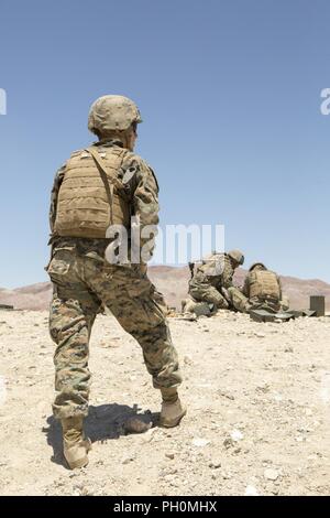 Le Cpl. Tristan Dugas, un chef d'équipe avec la Compagnie A, 1er Bataillon, 23e Régiment de Marines, 4e Division de marines, observe son équipe recharger leur mitrailleuse M240 lors d'un cours d'assaut d'air intégré à l'exercice de formation 4-18, à bord de Marine Corps Air Ground Combat Center Twentynine Palms, Californie, le 16 juin 2018. L'ITX 4-18 fournit sur les éléments du groupe de travail l'occasion de se soumettre à des évaluations des compétences de niveau de service afin qu'ils puissent s'intégrer de façon transparente avec le service actif Marines en cas de crises qui nécessite une réponse rapide. Banque D'Images