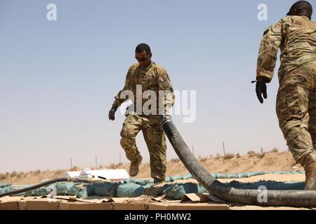 Les membres de l'armée américaine avec le 3e régiment de cavalerie, travailler à une aire de stockage de carburant à Al Qaim, l'Iraq, le 15 juin 2018. Il y a 75 partenaires de la Coalition engagés à l'objectif d'éliminer la menace posée par ISIS en Iraq et la Syrie et ont contribué à divers titres à l'effort. Banque D'Images