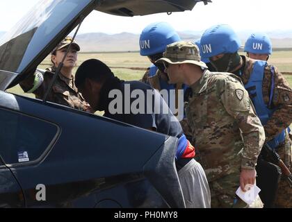 Le sergent de la Garde nationale de l'armée américaine. Stephen Fritts, siège de l'Administration centrale et compagnie, 297e groupe d'appui régional, donne des Forces armées mongoles dans l'encerclement et de recherche lane pendant KHAAN QUEST 2018 Collines à cinq secteurs d'entraînement le 18 juin. Le but de KQ18 est d'acquérir la formation et l'Organisation des Nations Unies le ceritficationfor participants grâce à la conduite d'opérations de paix, qui incluent l'augmentation et l'amélioration des opérations de maintien de la paix de l'interopérabilité et les relations militaires entre les pays participants. Banque D'Images