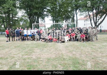 Des soldats américains affectés à la 91e bataillon du génie, 1re Brigade de blindés de combat, l'équipe de 1ère Division de cavalerie et à l'entreprise B, 151e Bataillon des transmissions du Corps expéditionnaire, Caroline du Sud, de la Garde nationale posent pour une photo de groupe avec des soldats affectés à la 23e Brigade d'artillerie, les forces terrestres polonaises au cours de la 243e anniversaire de l'Armée de terre polonaise qui s'est tenue à la base des Forces canadiennes à Boleslawiec, Pologne, le 14 juin 2018. La célébration conjointe inclus une base-wide, exécuter les événements sur le terrain, et un gâteau symbolique. Banque D'Images