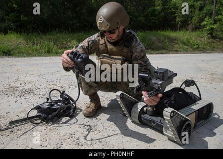 Le sergent du Corps des Marines des États-Unis. Jay, Steenbergn avec des explosifs et munitions, 8e compagnie, 2e Bataillon d'appui du Groupe de la logistique maritime, attache un moniteur de rayonnement linéaire à un iRobot 310 petits véhicules véhicule terrestre à Camp Lejeune, en Caroline du Nord, le 14 juin 2018. Marines formés pour détecter plusieurs types de menaces de se préparer pour un déploiement prochain. Banque D'Images