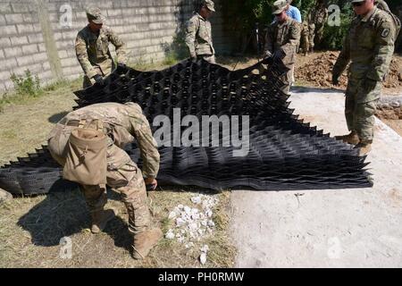 Les parachutistes de l'Armée américaine affecté à la Compagnie Bravo du 54e bataillon du génie de la Brigade, 173e Brigade aéroportée, coupe le net stabilisateur au cours de l'aérodrome de lumière et de réparation Réparation de cratère avec le Haut formation ingénieur Mobilité (Pelle HMEE) près de Trecenta , Rovigo, 20 juin 2018. La 173e Brigade aéroportée, basée à Vicenza, Italie, est l'armée américaine de la Force de réaction d'urgence en Europe, capables de projeter des forces canadiennes de mener toute la gamme des opérations militaires à travers les États-Unis, d'Europe et d'Afrique centrale Commandes domaines de responsabilité. Banque D'Images