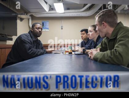 Mer (21 juin 2018) Spécialiste des opérations en chef Reginald Washington, gauche, parle avec marins et Marines au cours d'une réunion du comité multiculturel à bord de la classe de Harpers Ferry landing ship dock USS Oak Hill (LSD 51), le 21 juin 2018. Oak Hill, homeported à Virginia Beach, Virginie, mène des opérations navales dans la sixième flotte américaine zone d'opérations. Banque D'Images