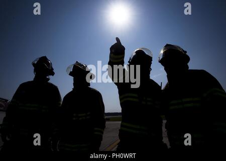 Les pompiers du 23e Escadron de génie civil (CES), discuter de stratégie avant un HH-60G Pave Hawk scénario de formation en sauvetage, le 19 juin 2018, à Moody Air Force Base, Ga. 23d ces pompiers effectué la formation pour évaluer leur connaissance et préparation de la façon d'éteindre et de sauvetage de l'équipage d'un HH-60. Banque D'Images