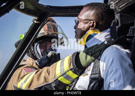 James Senior Airman Muncy, gauche, 23d de l'Escadron du Génie Civil (CES) pompier, applique un neck brace sur Charlie Johnson, 23d Ces sous-chef des pompiers, lors d'un HH-60G Pave Hawk sauvetage simulé le scénario de formation, le 20 juin 2018, à Moody Air Force Base, Ga. 23d ces pompiers effectué la formation pour évaluer leur connaissance et préparation de la façon d'éteindre et de sauvetage de l'équipage d'un HH-60. Banque D'Images