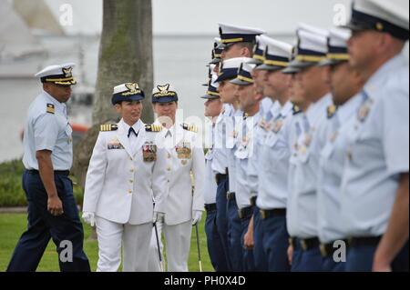 Capt Charlene Downey et le capitaine Monica Rochester procéder à une inspection de la Garde côtière de Los Angeles-Long Beach secteur personnel avant leur cérémonie de passation de commandement tenue à la base à San Pedro, Californie, le 22 juin 2018. Rochester remplacé Downey au poste de commandant du secteur avant de Downey a pris sa retraite après 26 années de service. Banque D'Images