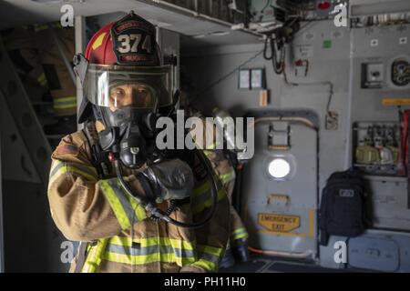 Junichiro Sugita, 374e Escadron de génie civile, pompiers communique avec son équipe pendant un exercice d'intervention d'urgence à Yokota Air Base, Japon, le 25 juin 2018. Aviateurs de la 730th Escadron de mobilité aérienne et 374cse a effectué une simulation d'incendie à bord d'un C-17, de familiarisation et de formation. Banque D'Images