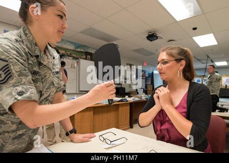 Le sergent-chef de l'US Air Force. Julie Brown (à gauche), un infirmier de la Garde nationale aérienne du Texas's 136th Airlift Wing, Lindsey aide à Howard de Richmond, Ky., sélectionnez cadre pour une nouvelle paire de lunettes à un dispensaire de soins de santé géré par la garde de l'air et de la Marine Réserve à Estill Comté High School, à Irvine, Ky., 21 juin 2018. La clinique est l'un des quatre qui composent l'opération Bobcat, une mission de 10 jours pour fournir des troupes médical militaire avec la formation indispensable dans les opérations sur le terrain et la logistique tout en offrant des soins de santé sans frais pour les résidents de l'Est de l'Illinois. Les cliniques, qui exploitait f Banque D'Images