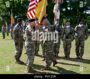 Le colonel Douglas S. Lowrey, 409ème Partie sortant du commandant de brigade de soutien (à droite) passe l'unité couleurs au major général Steven A. Shapiro, général commandant la 21e, pendant la commande Soutien Théâtre 409ème Partie appuyer la Brigade cérémonie de passation de commandement, le 22 juin 2018 à Kaiserslautern, Allemagne Banque D'Images